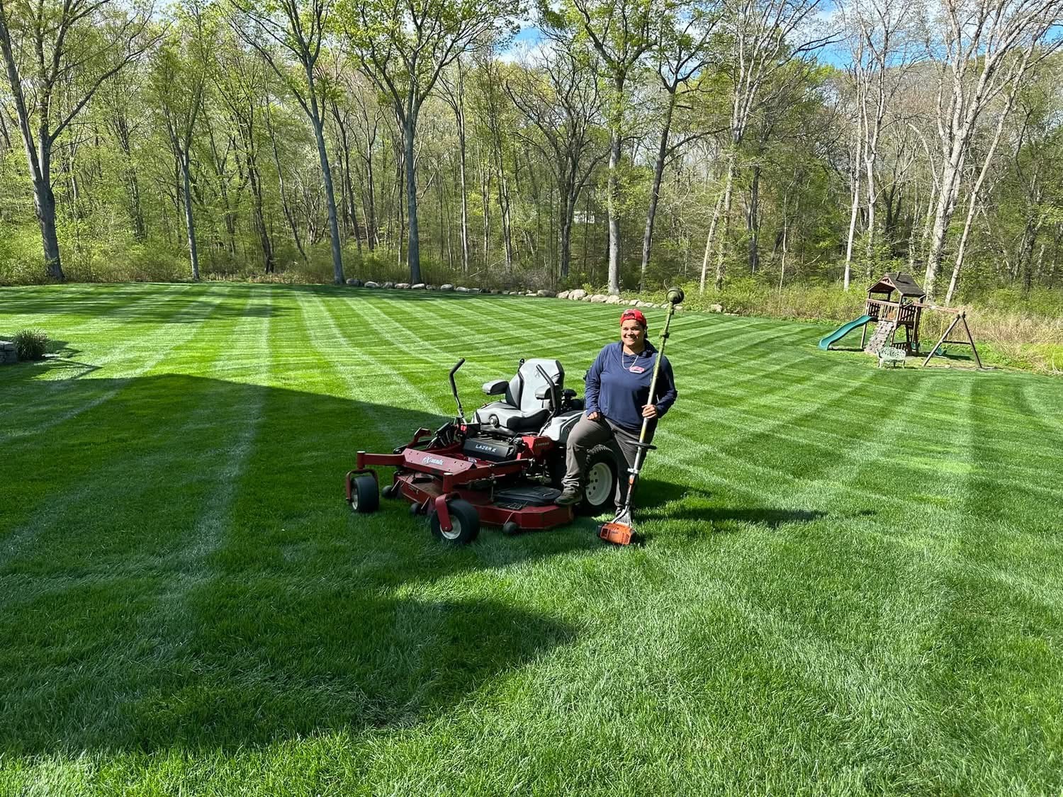 Giovanni Lawn Care team maintaining a healthy, striped green lawn